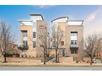 Modern multi-story home with brick and light-colored siding, metal roof, and small balconies at 2314 S University Blvd, Denver, CO 80210