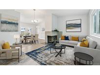 Bright living room showcasing a fireplace, modern furnishings, and a seamless transition to the dining area at 3932 S Pagosa St, Aurora, CO 80013