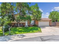 Charming two-story home with a brick facade, attached garage, and mature trees in a sunny, landscaped front yard at 5372 E 108Th Pl, Thornton, CO 80233