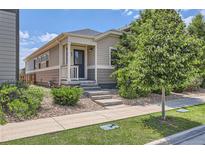 Charming home with well-maintained landscaping, stone covered flower beds, and a cozy covered front porch at 65 Avocet Ct, Longmont, CO 80501