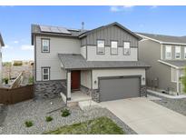 Two-story home featuring stone accents, solar panels, a two-car garage, and a well-maintained lawn at 16369 Alberta Dr, Parker, CO 80134