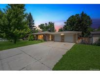 Charming single-story brick home with an attached two-car garage and a long driveway at 100 Dudley St, Lakewood, CO 80226