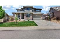 Charming two-story home with manicured lawn, a basketball hoop, and an attached two car garage at 22527 E Layton Cir, Aurora, CO 80015