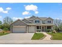 Charming two-story home featuring a landscaped front yard, gray brick, and an attached two-car garage at 708 Teal Cir, Longmont, CO 80503