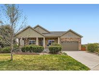 Charming single-story home with a stone and siding facade, complemented by a well-maintained lawn and landscaping at 6216 E 135Th Ave, Thornton, CO 80602