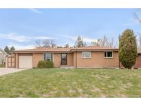 Charming single-story brick home features a well-maintained lawn, an attached garage, and an inviting entryway at 117 S Pierce St, Lakewood, CO 80226