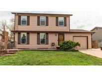 Charming two-story home with brown siding, well-maintained lawn, and attached garage at 17882 E Wyoming Pl, Aurora, CO 80017