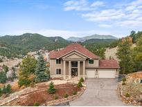 Stunning two-story home with mountain views, a well-manicured lawn, and a convenient three-car garage at 3191 Bittersweet Ln, Evergreen, CO 80439