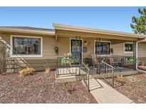 Charming home featuring a welcoming front entrance with a cozy porch and decorative iron railings at 1801 S Meade St, Denver, CO 80219