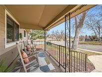Relaxing front porch with rocking chairs, outdoor rug and decorative metal railings, perfect for enjoying the neighborhood view at 1801 S Meade St, Denver, CO 80219