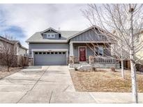 Charming home with a covered front porch, stone accents, and a well-manicured lawn at 6495 S Harvest St, Aurora, CO 80016