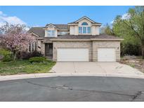 Charming two-story brick home featuring an attached three-car garage and a well-maintained front yard at 5485 S Jasper Ct, Centennial, CO 80015