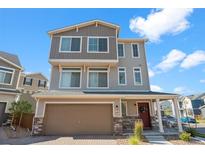 Attractive three-story home with a two-car garage, covered porch, and neutral-toned siding and brick accents at 10152 Xanadu St, Commerce City, CO 80022