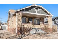 Charming front of house with brick exterior and steps leading to the porch at 1453 Utica St, Denver, CO 80204