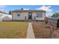 Charming single-story home featuring a well-maintained lawn, inviting front porch, and a classic facade at 8074 Grove St, Westminster, CO 80031