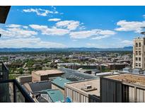 Expansive city view featuring high-rise buildings and the beautiful mountain skyline in the background under a partly cloudy sky at 891 14Th St # 2105, Denver, CO 80202