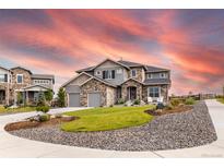 Beautiful two-story home featuring stone accents, a manicured lawn, and a welcoming entrance at 11522 Trona Ct, Parker, CO 80138
