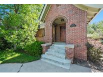Inviting brick home entrance with a charming arched doorway and well-manicured landscaping at 1278 Dexter St, Denver, CO 80220