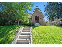 Charming brick home with a landscaped front yard and steps leading to the front door at 1278 Dexter St, Denver, CO 80220