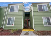 Green two story building with stairs leading to the entrance and white trimmed windows at 956 S Peoria St, Aurora, CO 80012