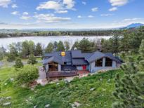 Aerial view of a stunning lakefront home with a spacious deck and scenic surroundings at 3021 N Lakeridge Trl, Boulder, CO 80302