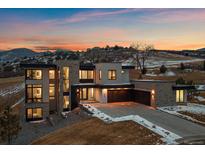 Contemporary home with modern architecture, stone accents, three-car garage and mountain views at sunset at 5263 Creation Rock Trl, Morrison, CO 80465