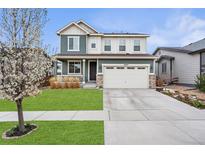 Charming two-story home featuring a well-manicured lawn and attached two-car garage at 18077 E 99Th Ave, Commerce City, CO 80022