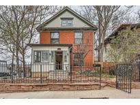 Charming brick two-story home featuring a well-manicured front yard and inviting entrance at 1474 Clayton St, Denver, CO 80206