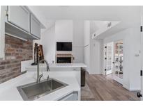Well-lit kitchen with stainless steel sink, brick wall accent, and white countertops at 4824 E Kentucky Ave # F, Denver, CO 80246