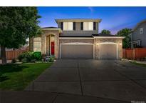 Charming two-story home with a brick facade, manicured lawn, and a two-car garage, perfect for a growing Gathering at 16863 Trail View Cir, Parker, CO 80134