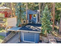 Charming blue two-story home with a red front door and an attached garage at 26378 S End Rd, Kittredge, CO 80457