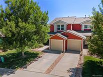 Charming townhome featuring a well-manicured front yard and attached two-car garage with a driveway at 351 Montgomery Dr, Erie, CO 80516