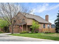 Inviting two-story home featuring a brick chimney, covered porch and lush, well-maintained front lawn at 7900 E Dartmouth Ave # 75, Denver, CO 80231
