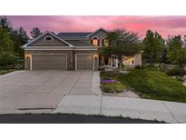 Charming two-story home with stone accents, a three-car garage, and a well-maintained lawn at 20510 Oakbrook Ln, Parker, CO 80138