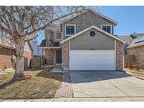 Charming two-story home with brick accents, a well-maintained lawn, and a two-car garage at 12144 Newport Dr, Brighton, CO 80602