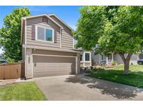 Charming two-story home with a two car garage, tidy landscaping, and a well-manicured front lawn at 9606 Whitecliff Pl, Highlands Ranch, CO 80129