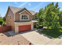 Charming two-story home featuring a red garage door, brick accents, and a well-manicured lawn at 13235 Clermont Cir, Thornton, CO 80241