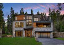 Striking modern home featuring stone accents, wood panels, an upper deck, and a spacious two-car garage at 27 Boulder Cir, Breckenridge, CO 80424
