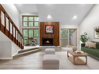 Bright living room features a wood fireplace, large windows, and access to a balcony at 701 Harlan St # E53, Lakewood, CO 80214