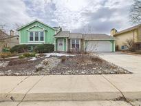 Inviting two-story home featuring charming green siding and a well-maintained front yard at 21278 E Aberdeen Pl, Centennial, CO 80015
