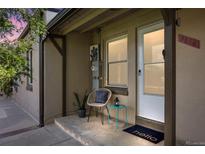 Charming front porch with a chair, side table, and a welcoming 'hello' doormat at 2616 Utica St, Denver, CO 80212