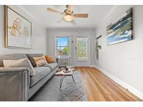Bright living room with hardwood floors, a ceiling fan, modern furnishings, and abundant natural light at 2616 Utica St, Denver, CO 80212