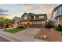 Beautiful two-story home with a well-maintained lawn, stone accents, and a two-car garage at 14278 Greenfield Loop, Parker, CO 80134