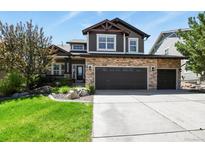 Charming two-story home featuring a stone facade and a spacious three-car garage at 7243 S Kellerman Way, Aurora, CO 80016
