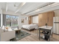 Bright living space with modern furnishings, light wood flooring, and a sliding door to a balcony at 1495 Vrain St # 115, Denver, CO 80204