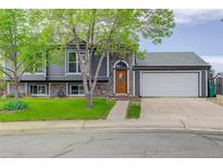 Charming gray home featuring stone accents, manicured lawn, and an attached two-car garage at 5861 S Orleans Way, Centennial, CO 80015
