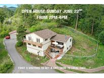 Charming multi-level home with wooden balconies and fencing, nestled in a lush, wooded area at 9648 Yegge Rd, Morrison, CO 80465