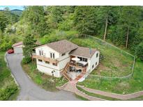 Inviting two-story home with a beautiful balcony and a spacious outdoor patio area at 9648 Yegge Rd, Morrison, CO 80465
