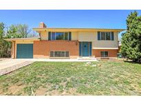 Charming two-story home with brick accents, blue door, and manicured lawn at 433 S Vaughn Way, Aurora, CO 80012