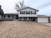 Two-story home with a gray exterior, white trim, black shutters, and an attached two-car garage at 12970 E 47Th Avenue Cir, Denver, CO 80239